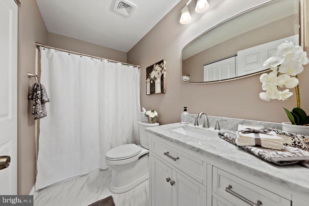 133 Tavistock Cherry Hill, NJ 08034 - Photo 24 of 35 a bathroom with a granite countertop sink a toilet and a mirror
