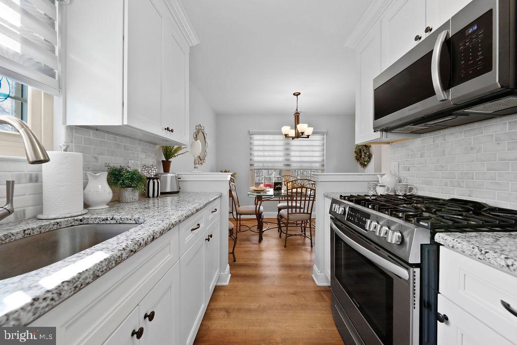 133 Tavistock Cherry Hill, NJ 08034 - Photo 10 of 35 a kitchen with stainless steel appliances granite countertop a stove a sink and a microwave