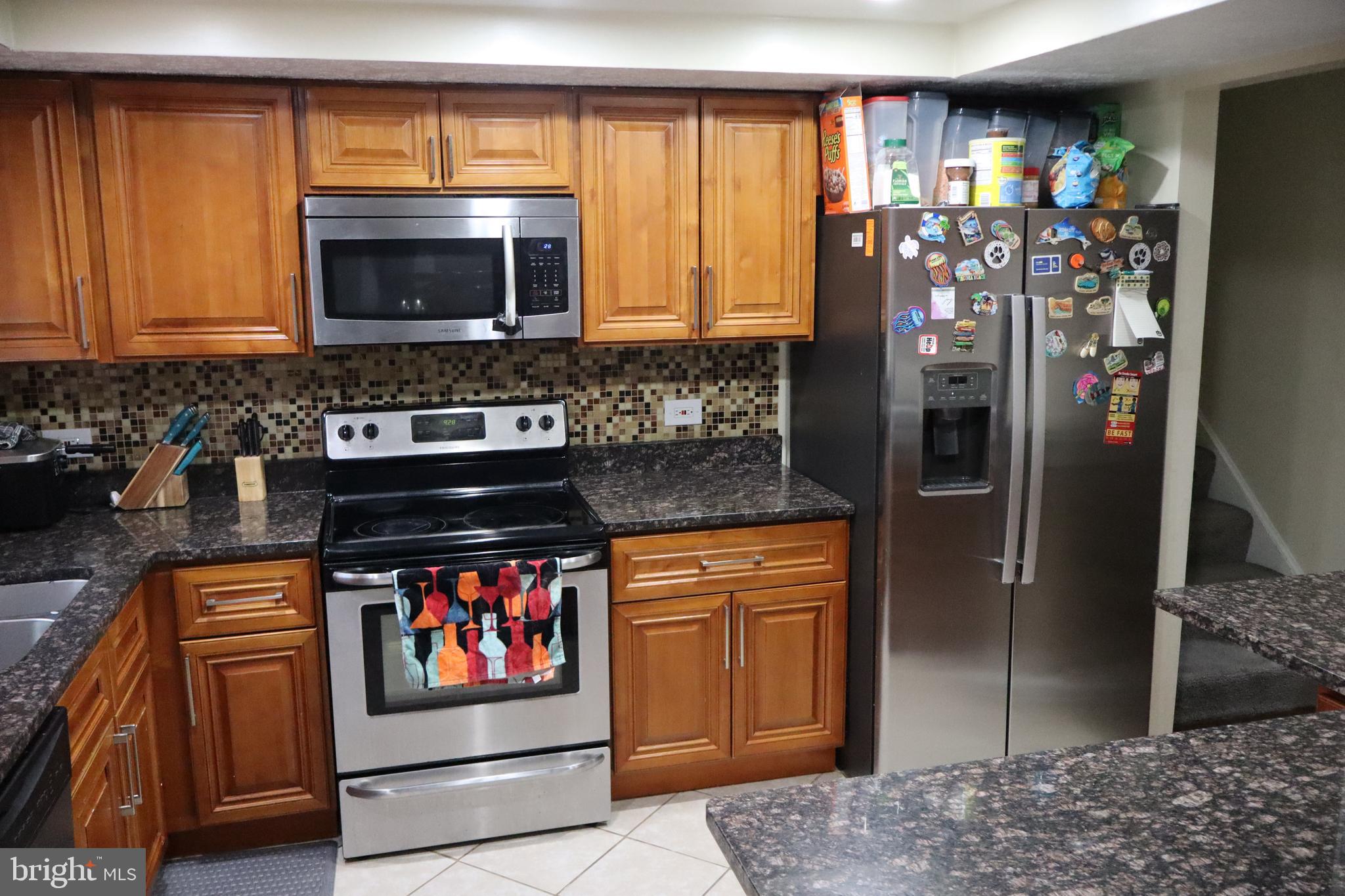 10916 Bridle Path Circle Waldorf, MD 20601 - Photo 3 of 36 a kitchen with stainless steel appliances granite countertop a stove refrigerator and a microwave