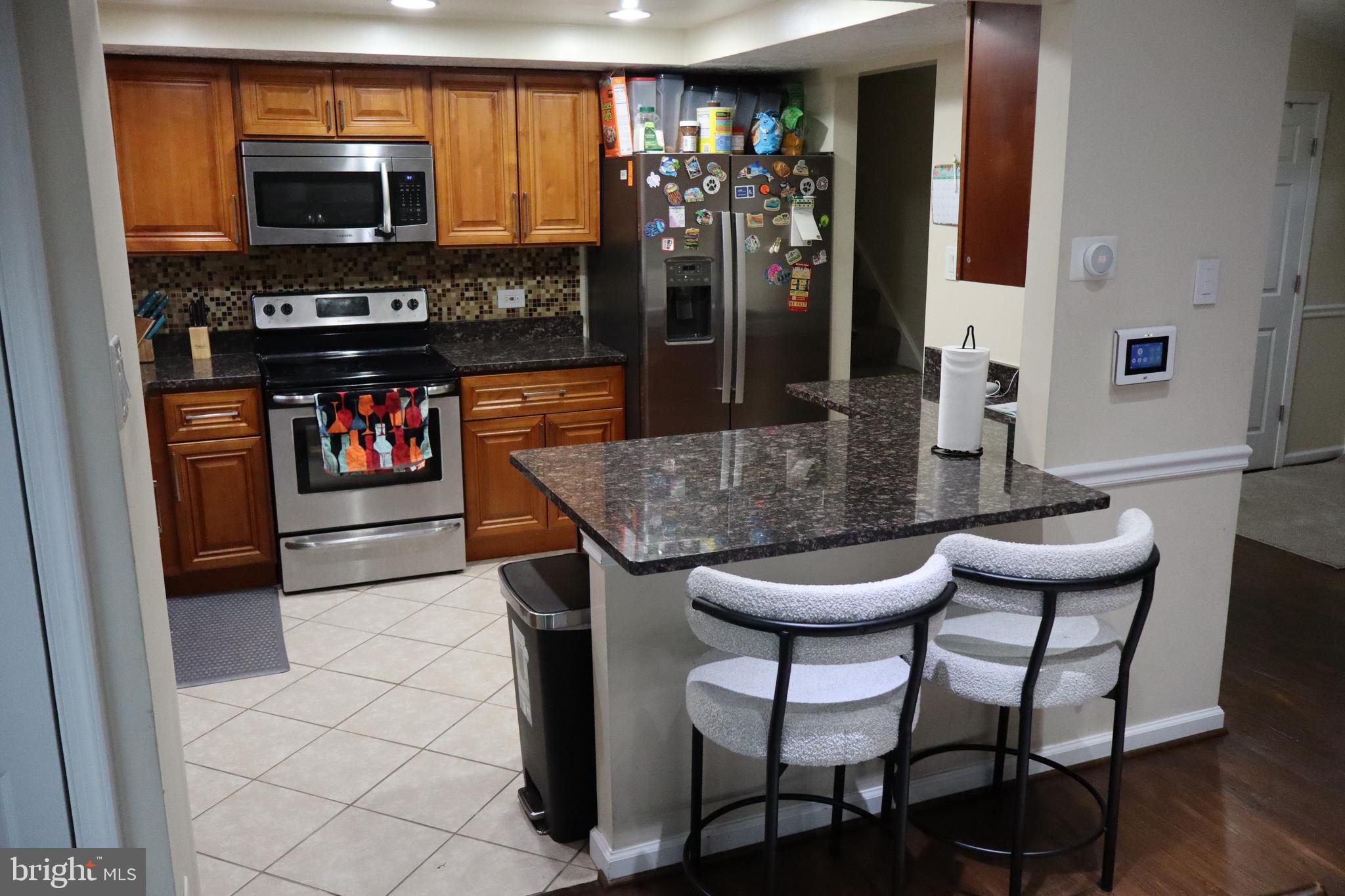 10916 Bridle Path Circle Waldorf, MD 20601 - Photo 4 of 36 a kitchen with stainless steel appliances kitchen island granite countertop a table and chairs in it