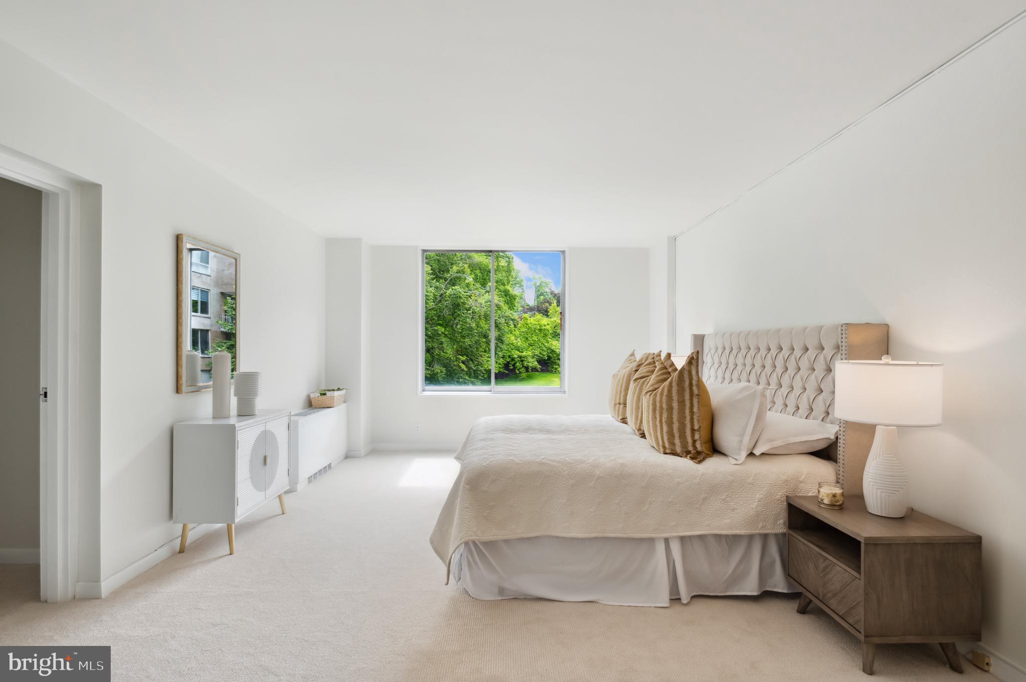 4100 Cathedral Avenue Northwest, Unit 709 Washington, DC 20016 - Photo 6 of 20 a bedroom with a bed and a lamp