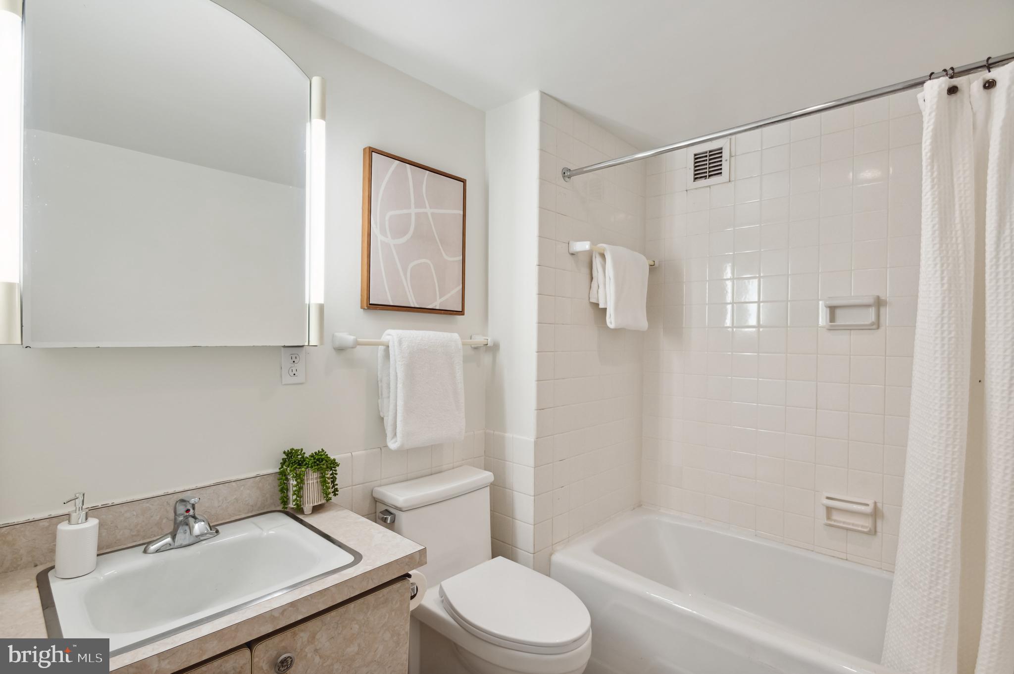 4100 Cathedral Avenue Northwest, Unit 709 Washington, DC 20016 - Photo 7 of 20 a bathroom with a sink toilet and shower