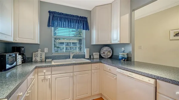 a kitchen with granite countertop a sink a stove and cabinets