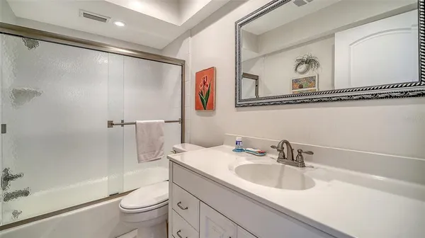 a bathroom with a sink a toilet and a large mirror