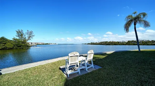 a view of a lake with table and chairs