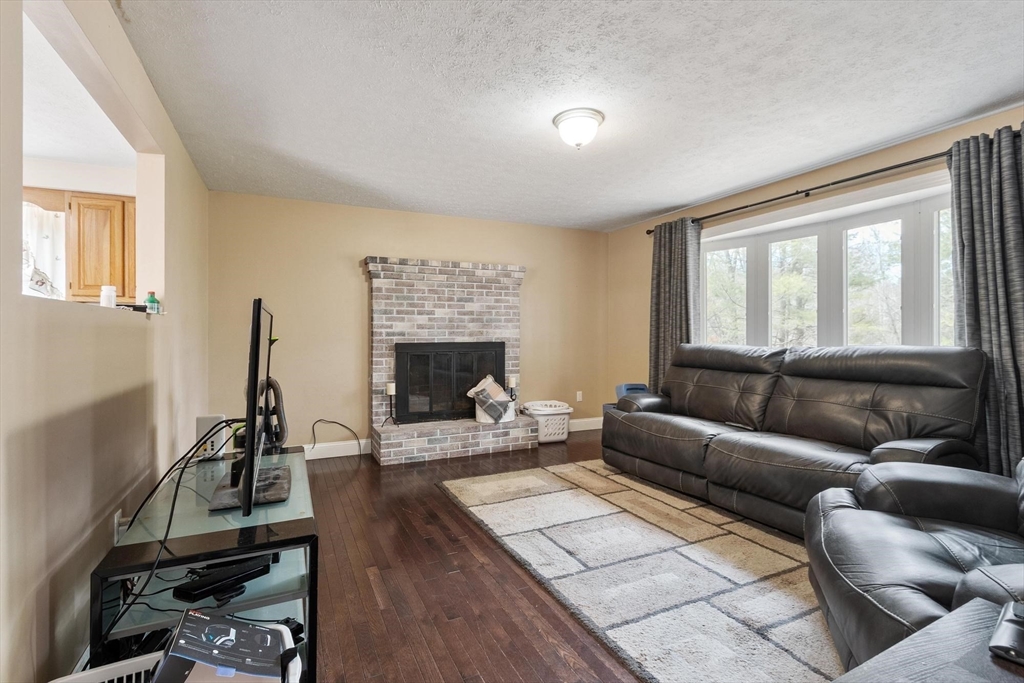 681 Teel Road Winchendon, MA 01475 - Photo 13 of 27 a living room with furniture a fireplace and a flat screen tv