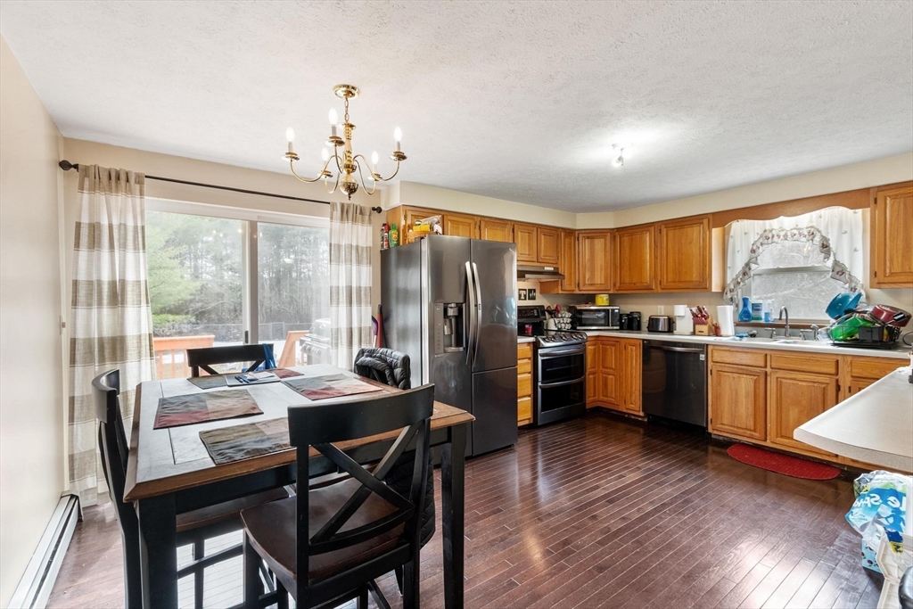681 Teel Road Winchendon, MA 01475 - Photo 15 of 27 a kitchen with a table chairs refrigerator and microwave