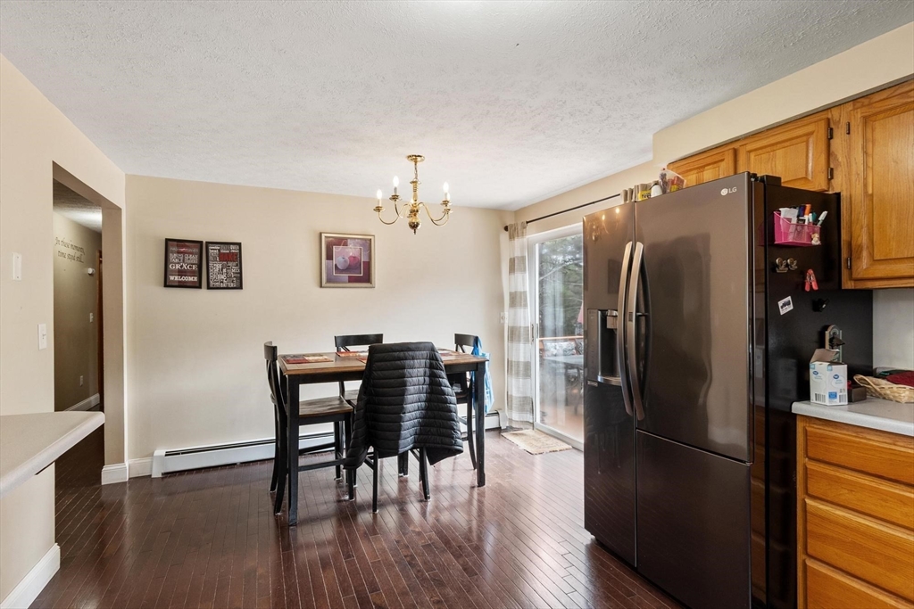 681 Teel Road Winchendon, MA 01475 - Photo 16 of 27 a kitchen with stainless steel appliances granite countertop a refrigerator a stove a dining table and chairs with wooden floor
