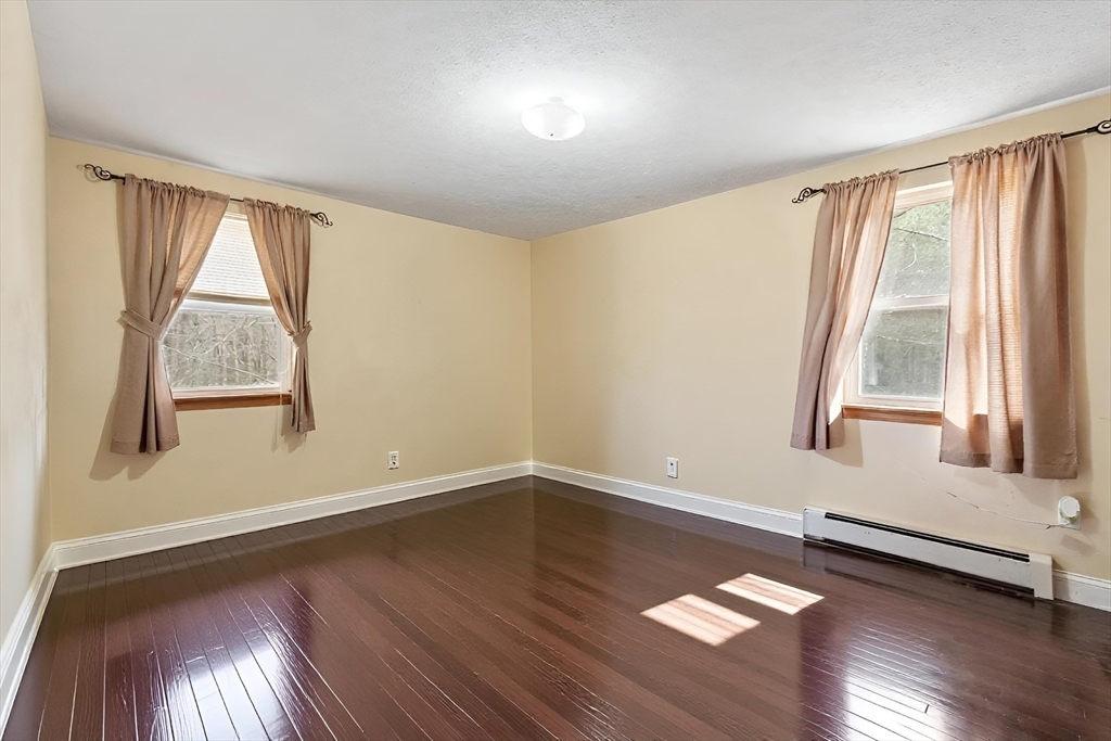 681 Teel Road Winchendon, MA 01475 - Photo 8 of 27 an empty room with wooden floor and windows