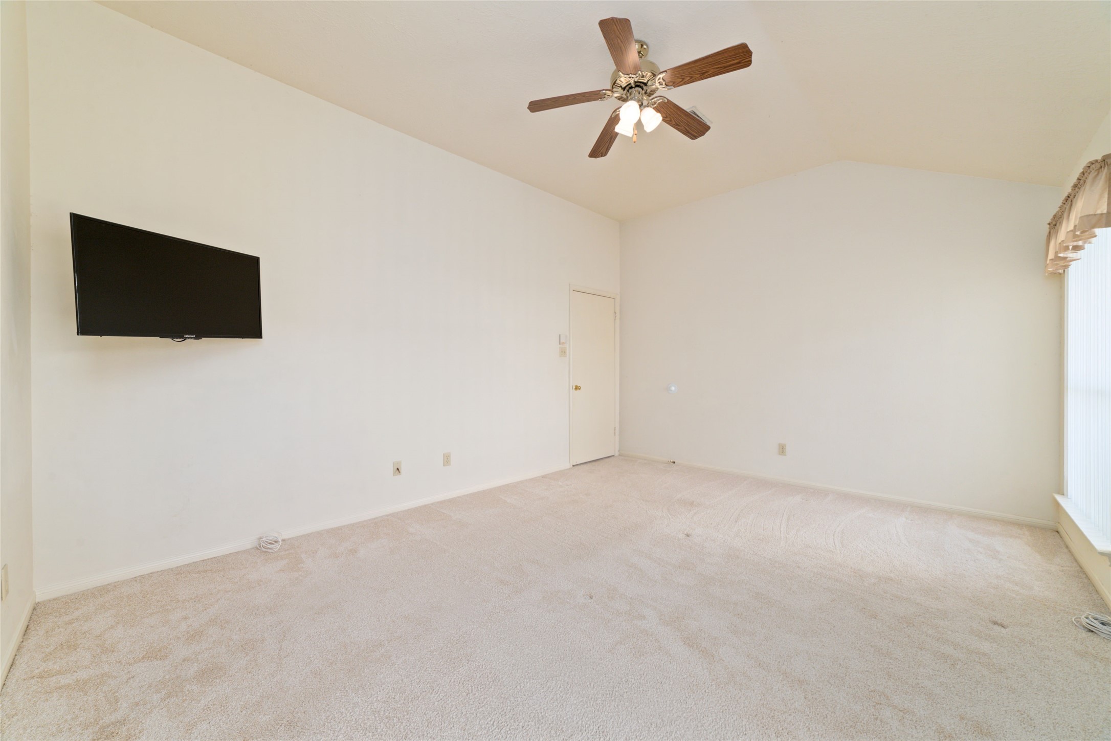 3327 Keygate Drive Spring, TX 77388 - Photo 26 of 37 an empty room with a flat screen tv and a ceiling fan