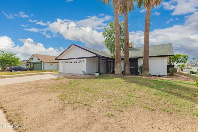 a view of a house with backyard and tree