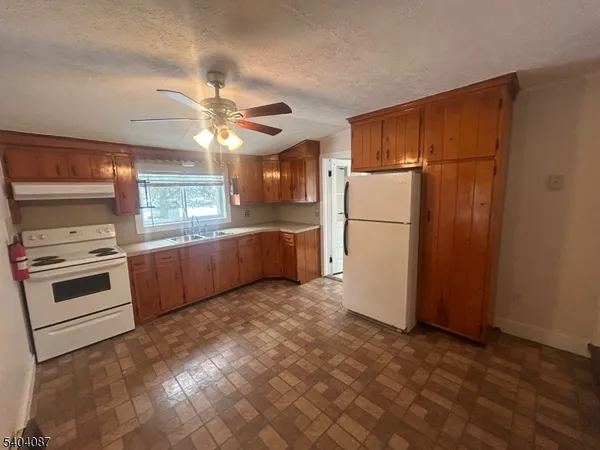 a kitchen with a refrigerator and a stove top oven