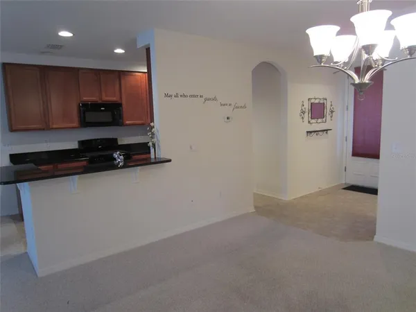 a view of kitchen with a sink a refrigerator and a chandelier
