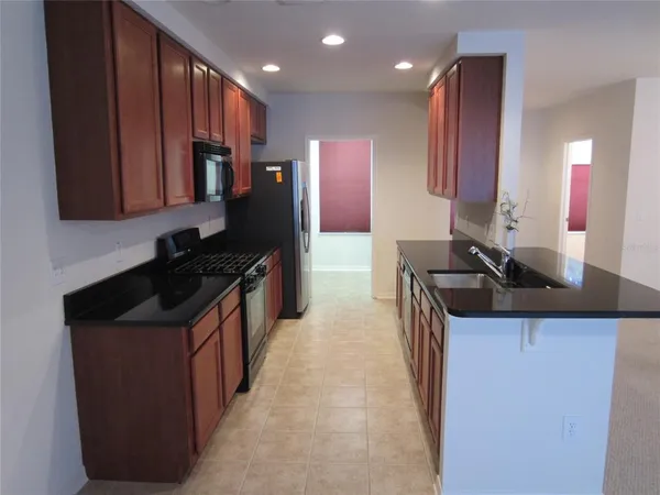 a kitchen with stainless steel appliances granite countertop a stove a sink and a refrigerator