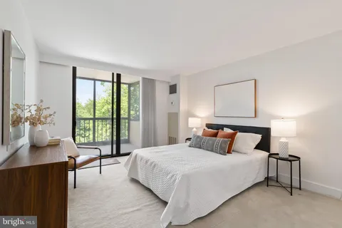 a bedroom with a large bed and a potted plant