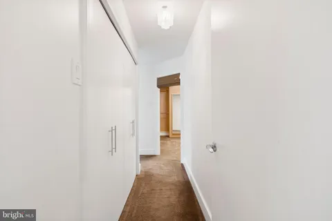 a view of a hallway with wooden floor and entryway