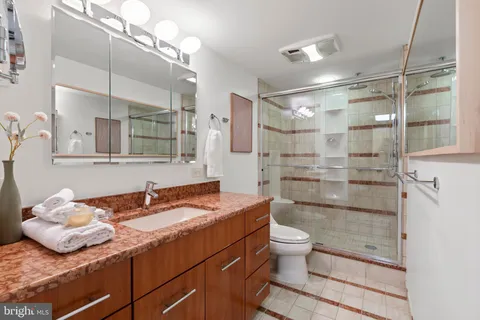 a bathroom with a sink a toilet and shower