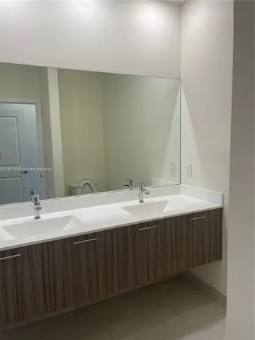 a bathroom with a double vanity sink and mirror
