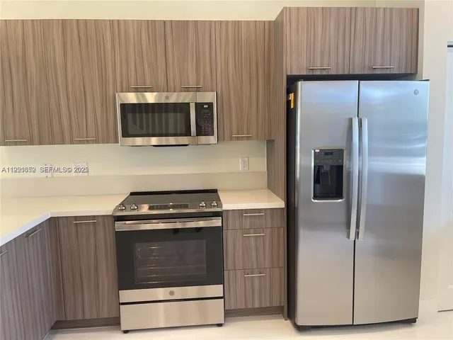 a kitchen with cabinets and stainless steel appliances