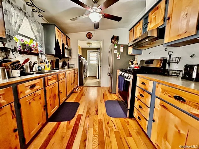 a kitchen with stainless steel appliances granite countertop lots of counter top space and wooden floor