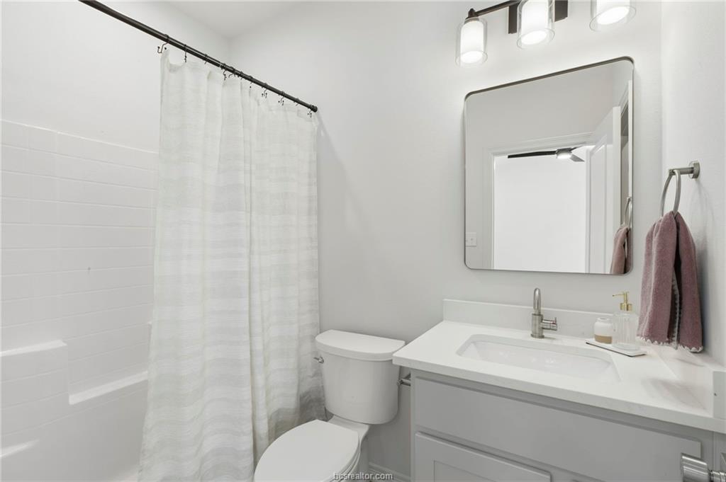 307 Sterling Street, Unit D College Station, TX 77840 - Photo 7 of 18 a bathroom with a sink vanity mirror and toilet