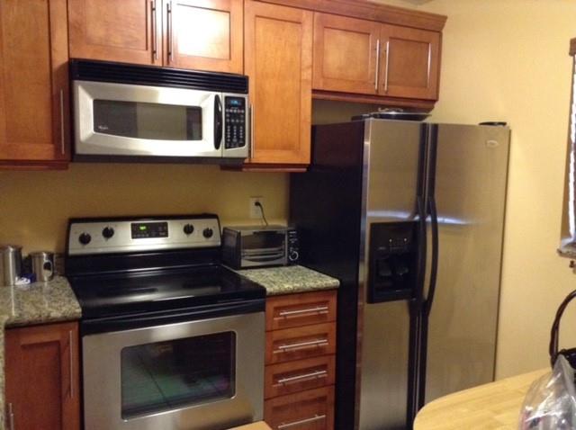 3199 Foxcroft Road, Unit 308 Miramar, FL 33025 - Photo 4 of 9 a kitchen with stainless steel appliances granite countertop a stove and a microwave