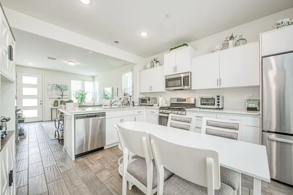 a kitchen with white cabinets stainless steel appliances and a center island