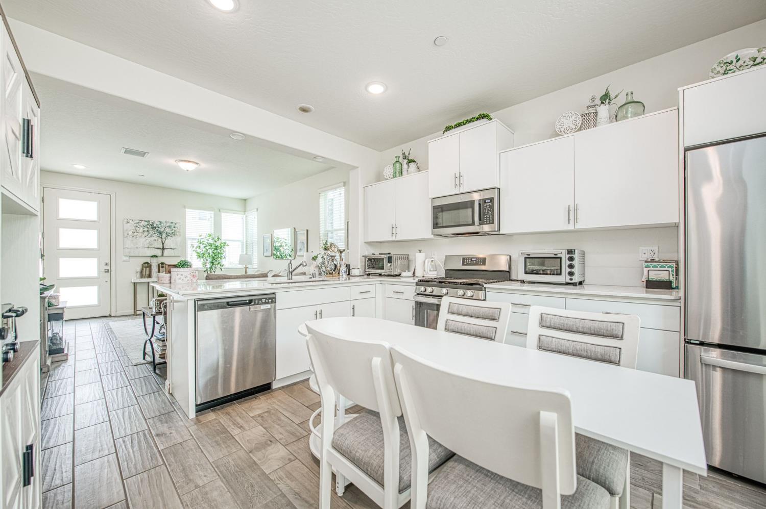 2053 North Ralph Lane Clovis, CA 93619 - Photo 12 of 31 a kitchen with white cabinets stainless steel appliances and a center island