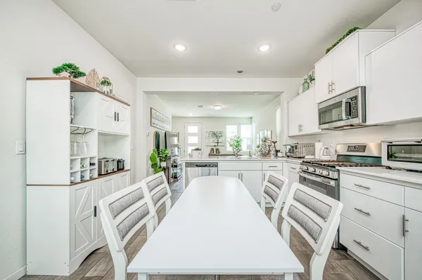 a kitchen with white cabinets and stainless steel appliances