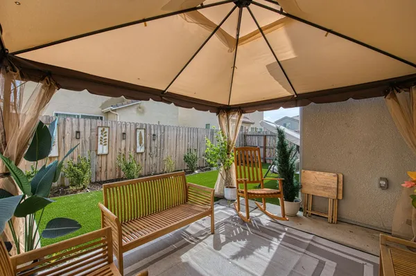 a view of backyard with barbeque grill and potted plants