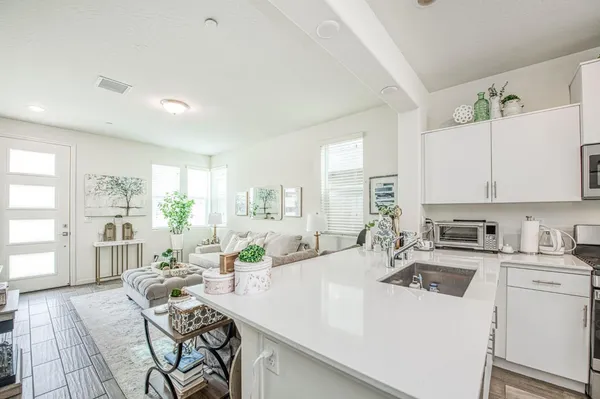 a kitchen with a sink a stove cabinets dining table and chairs