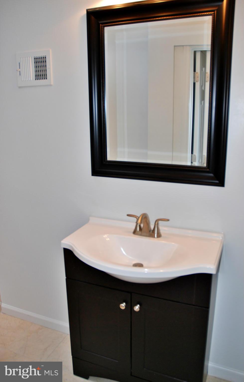 211 Thistle Drive Silver Spring, MD 20901 - Photo 16 of 23 a bathroom with a sink a mirror and vanity