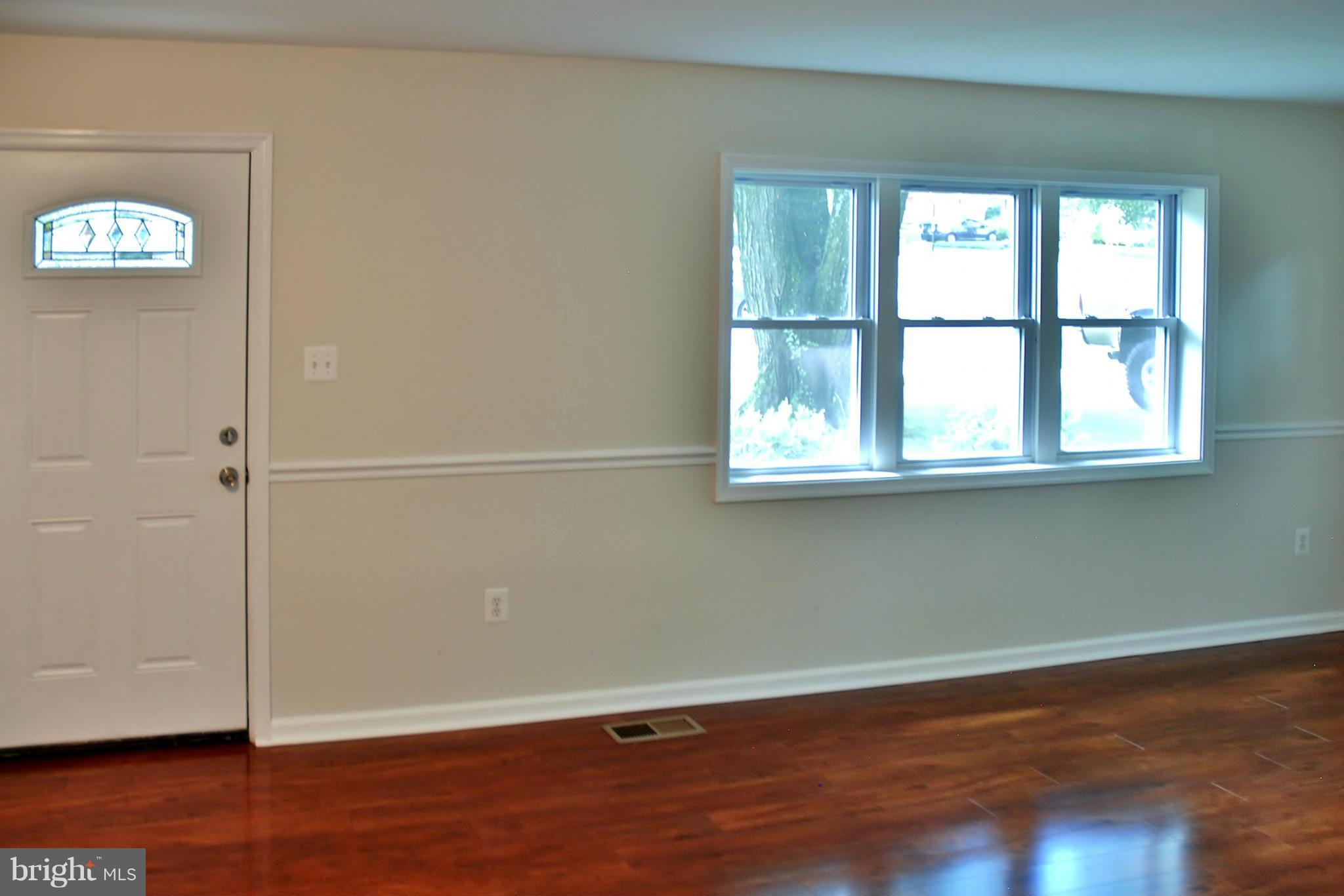 211 Thistle Drive Silver Spring, MD 20901 - Photo 3 of 23 an empty room with wooden floor and windows