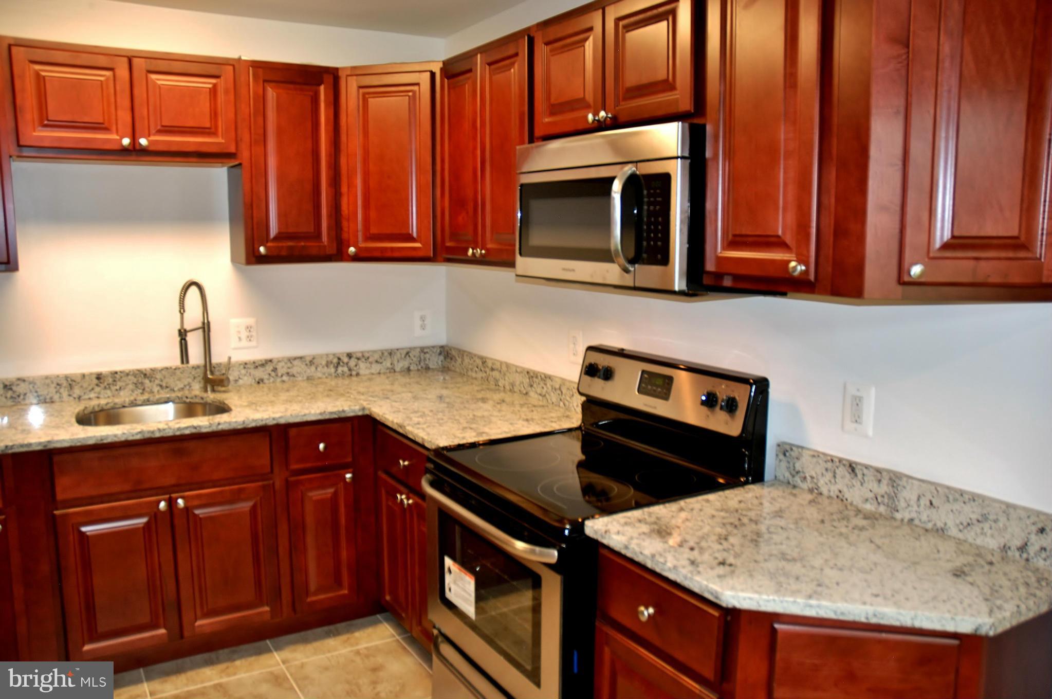 211 Thistle Drive Silver Spring, MD 20901 - Photo 7 of 23 a kitchen with stainless steel appliances granite countertop a sink stove and microwave