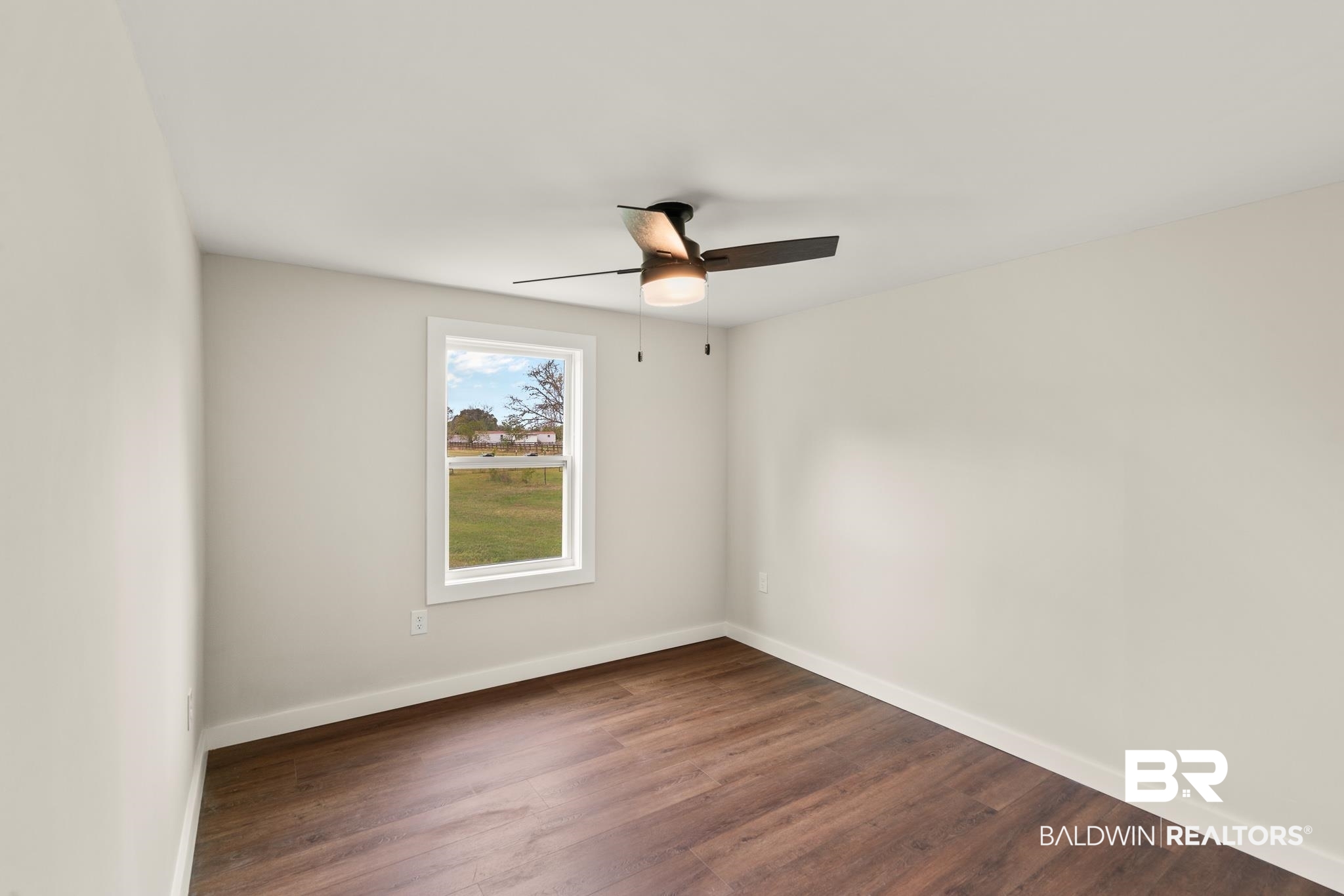12645 Breman Road Elberta, AL 36530 - Photo 25 of 44 Unfurnished room with baseboards, dark wood-type flooring, and a ceiling fan