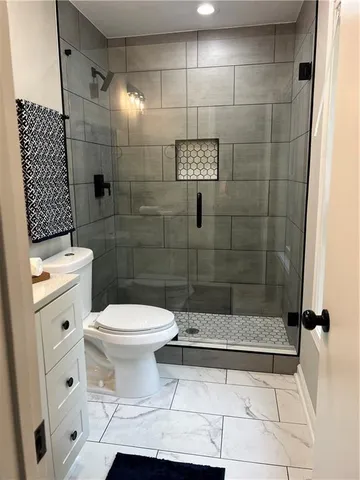 a bathroom with a sink a toilet and shower