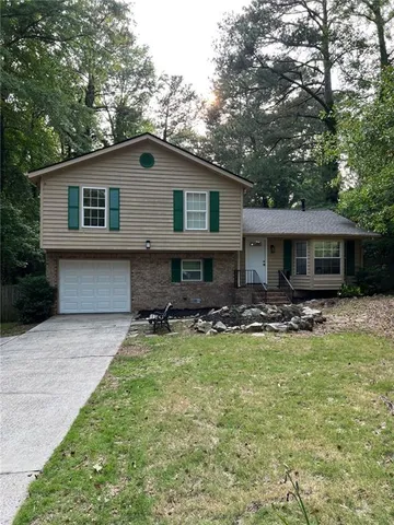 a view of a house with a yard and sitting area