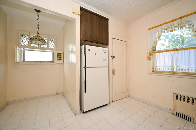 a refrigerator freezer sitting in a kitchen next to a window