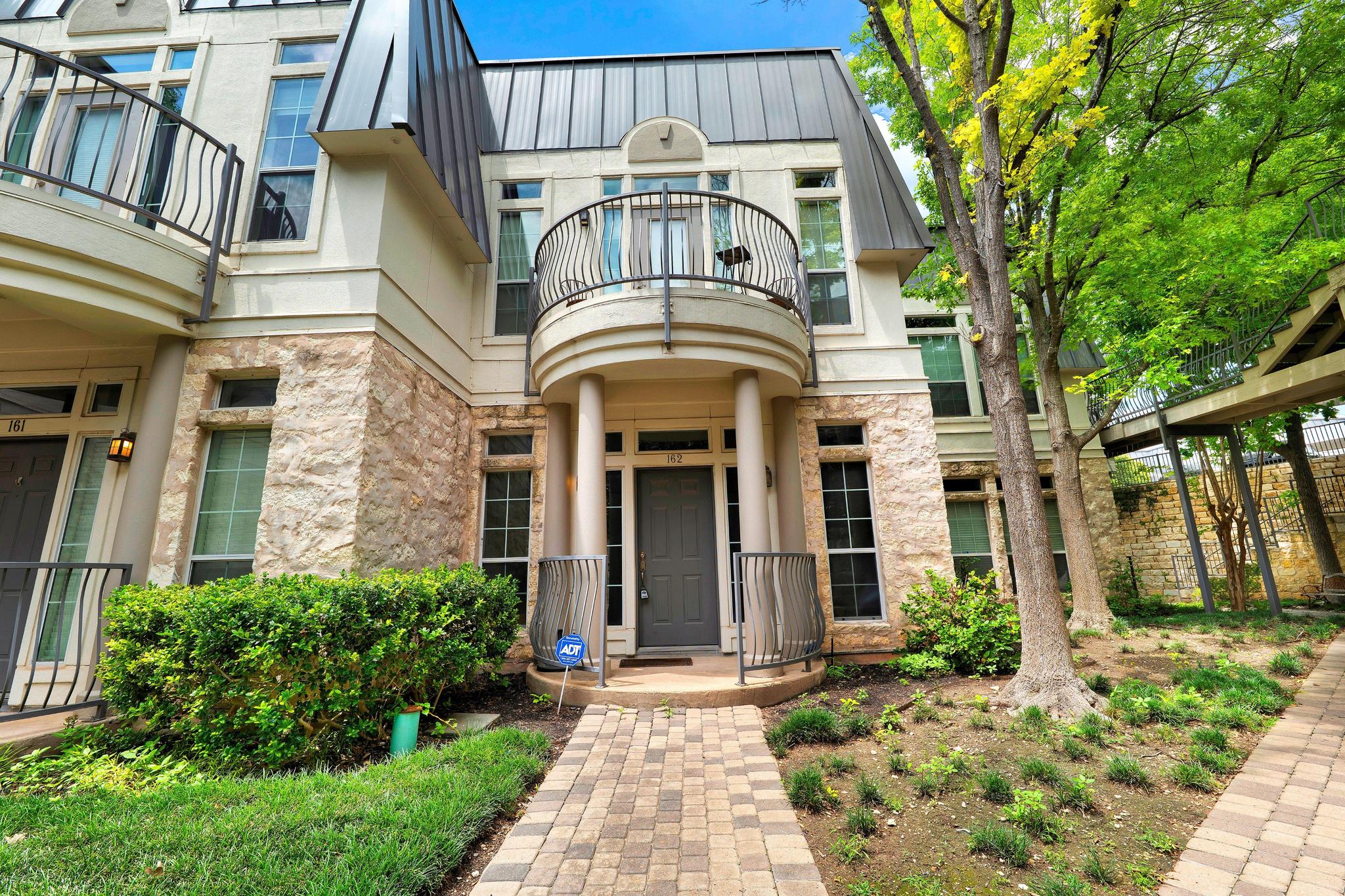 2918 Ranch Road 620, Unit J162 Austin, TX 78734 - Photo 1 of 26 Beautiful front entry with Juliet balcony above and paver walkway, metal mansard style metal roof