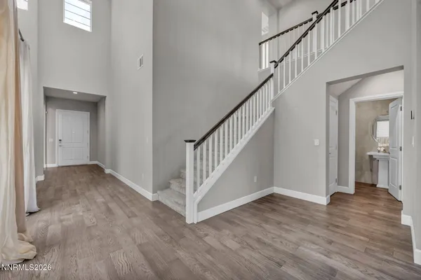 a view of a hallway with wooden floor and staircase