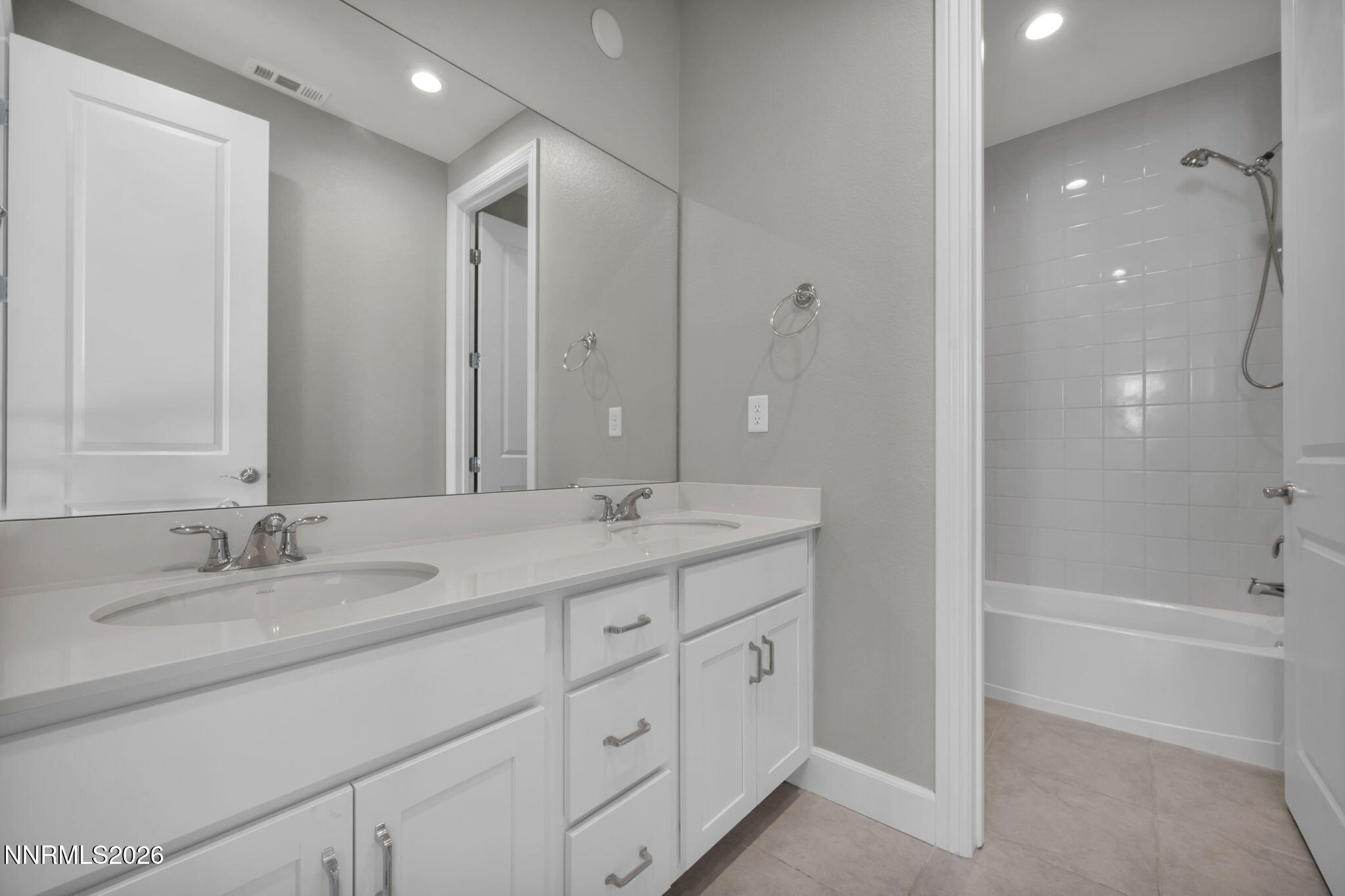 9267 Blue Basin Trail Reno, NV 89521 - Photo 59 of 95 a bathroom with a granite countertop sink two mirror and a bathtub