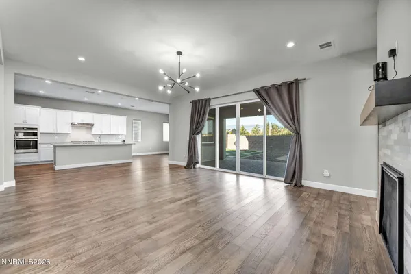 a view of a livingroom with a fireplace wooden floor and chandelier