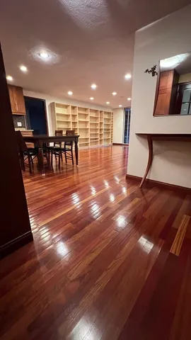 a view of a room with lots of furniture and wooden floor