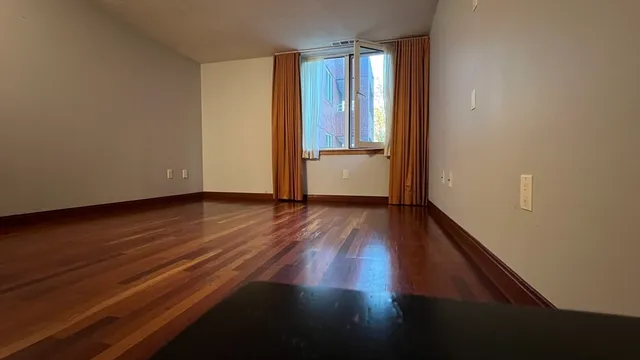 a view of a room with wooden floor and window
