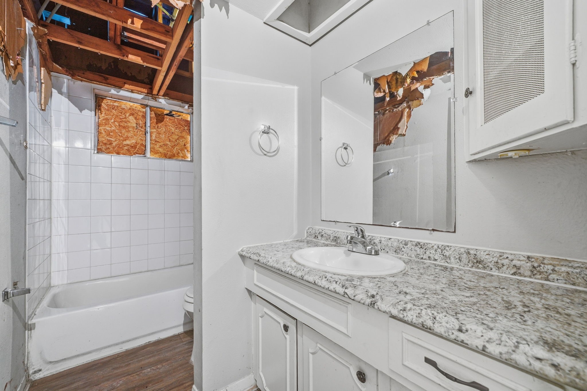 6410 Hopper Road Houston, TX 77016 - Photo 25 of 28 a bathroom with a granite countertop sink a mirror a bathtub and shower