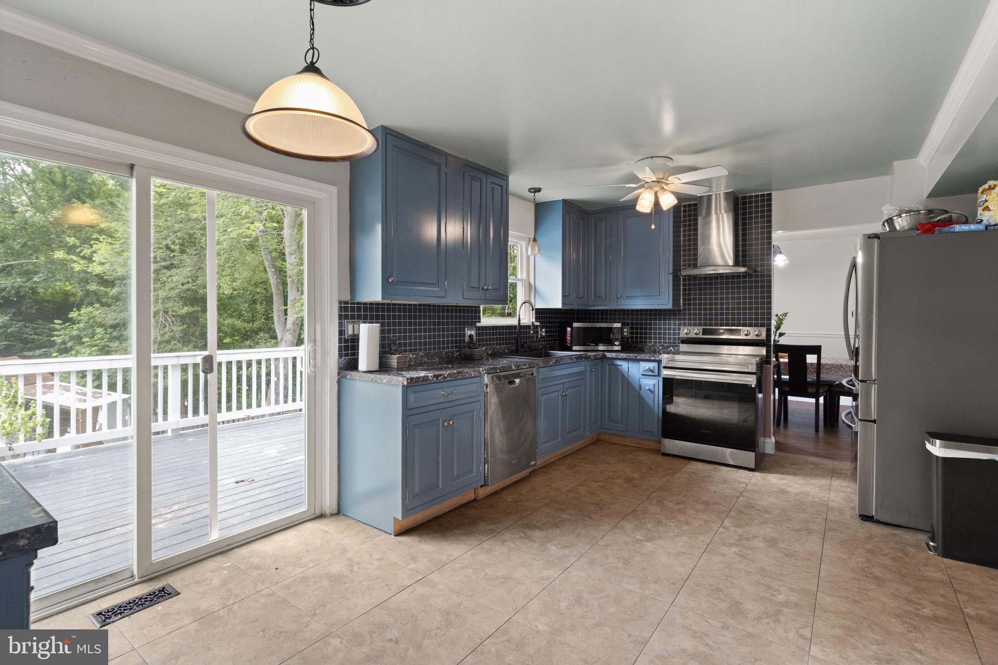 244 Raintree Boulevard Stafford, VA 22556 - Photo 7 of 34 a kitchen with granite countertop a stove a sink a kitchen island a refrigerator and a stove top oven