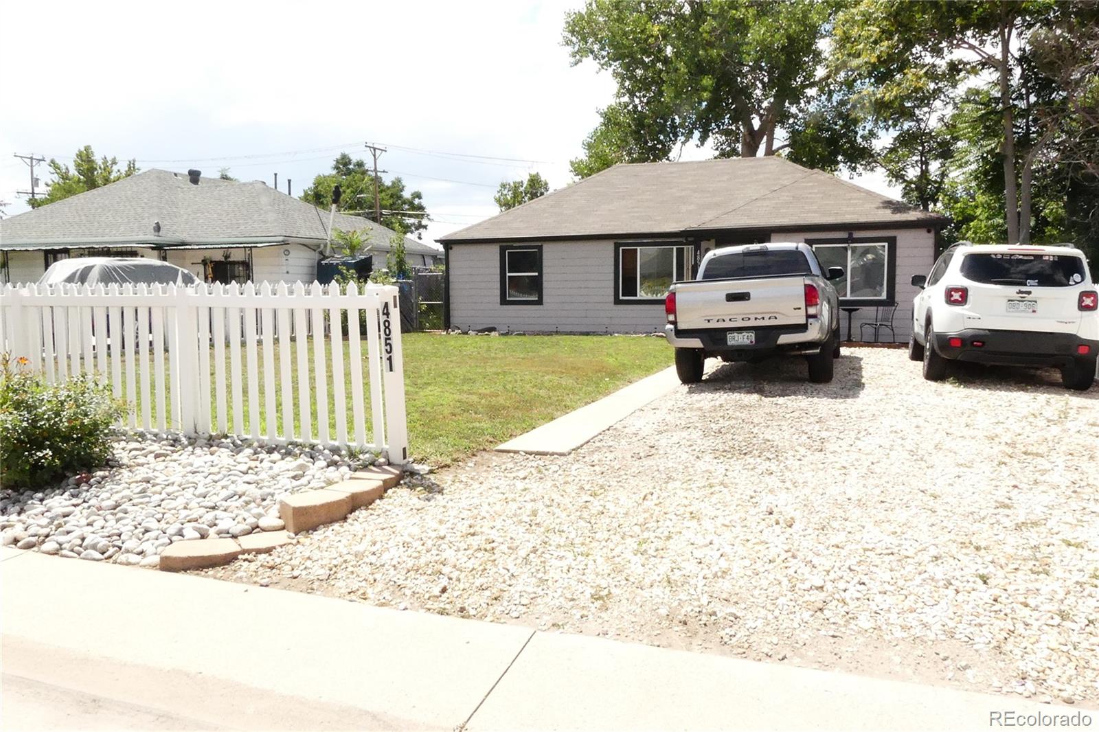 4851 Adams Street Denver, CO 80216 - Photo 1 of 30 a front view of a house with a yard