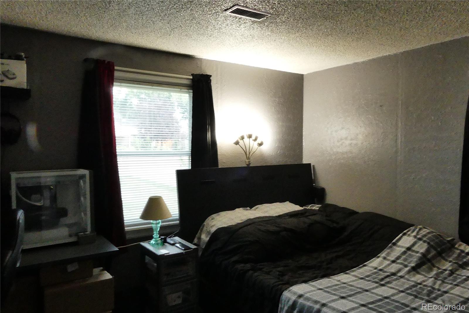 4851 Adams Street Denver, CO 80216 - Photo 13 of 30 a bedroom with a bed and a fireplace