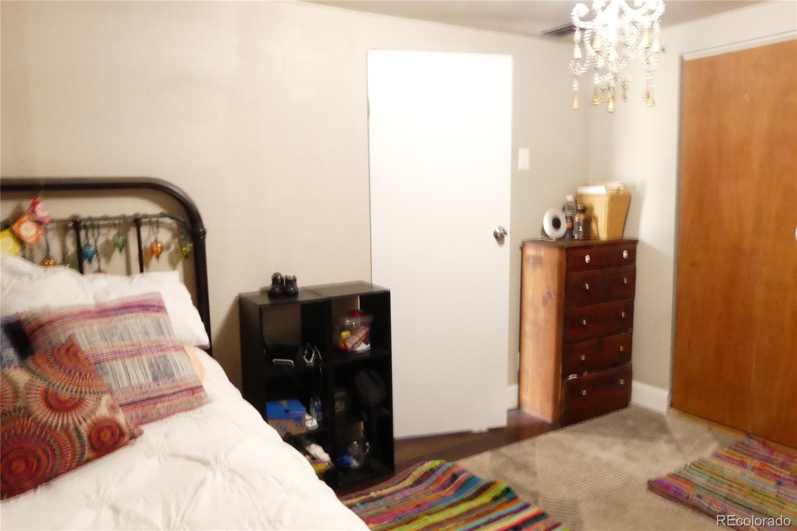 4851 Adams Street Denver, CO 80216 - Photo 14 of 30 a bedroom with a bed and a dresser
