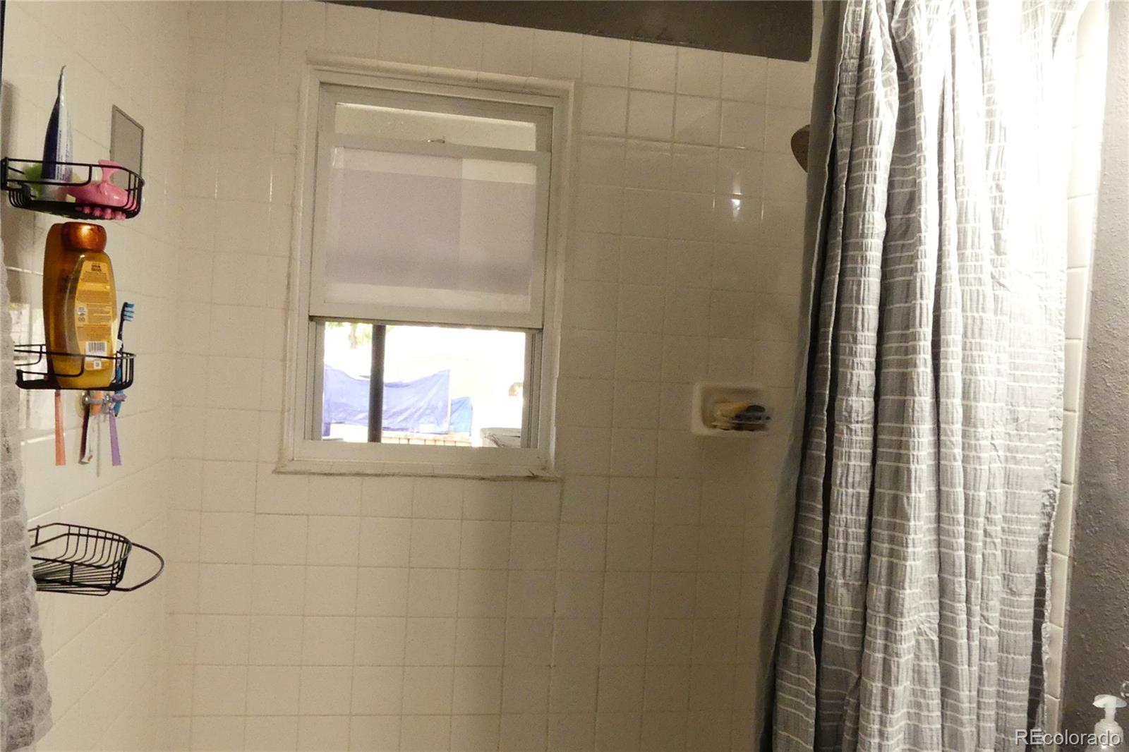 4851 Adams Street Denver, CO 80216 - Photo 16 of 30 a bathroom with a shower